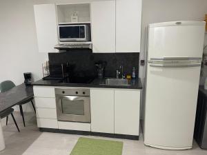 een keuken met een witte koelkast en een magnetron bij Caracas Aparto Suite La Boyera in Caracas