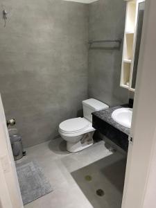 een badkamer met een wit toilet en een wastafel bij Caracas Aparto Suite La Boyera in Caracas