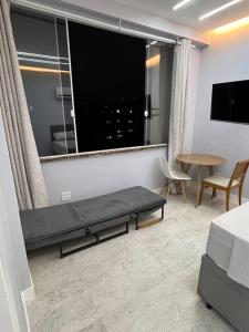 a living room with a bed and a large window at Studio Dowtown tech Rio in Rio de Janeiro