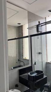 La salle de bains est pourvue d'un lavabo, de toilettes et d'un miroir. dans l'établissement Studio Dowtown tech Rio, à Rio de Janeiro