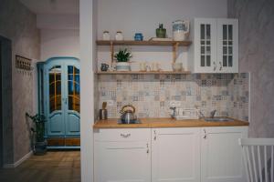 a kitchen with white cabinets and a blue cabinet at Lawendowy Raj in Pilchowice
