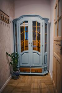 a blue cabinet in a hallway with a potted plant at Lawendowy Raj in Pilchowice +3 photos