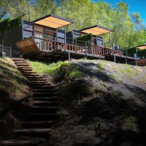 a house on top of a hill with stairs at Cabañas Habitainer BordeRio in Concepción