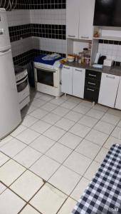 eine Küche mit weißen Geräten und schwarzen und weißen Fliesen in der Unterkunft Casa na Barra de São Miguel -AL in São Miguel dos Campos