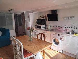 eine Küche mit einem Tisch und eine Küche mit einer Waschmaschine in der Unterkunft Alojamiento Casa Piano in Mairena del Aljarafe
