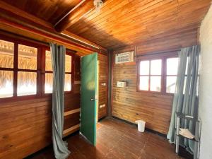 - une chambre avec une porte verte dans une maison en bois dans l'établissement El Arca, à Tintipan Island