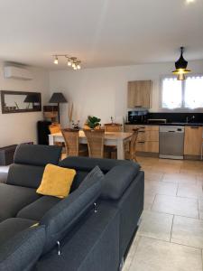 un salon avec un canapé bleu et une cuisine dans l'établissement L’aureilhannaise, à Aureilhan