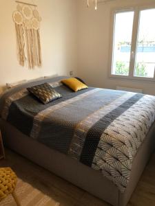 un grand lit dans une chambre avec une fenêtre dans l'établissement L’aureilhannaise, à Aureilhan