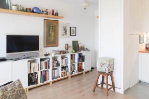 a living room with a tv and a book shelf at Lovely cozy cocoon at the gates of Paris in Romainville