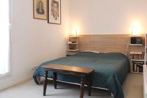 a bedroom with a bed with a table in it at Lovely cozy cocoon at the gates of Paris in Romainville