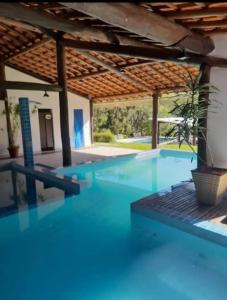 - une piscine d'eau bleue dans une maison dans l'établissement Estância das Nascentes Chalé 1, à Salesópolis