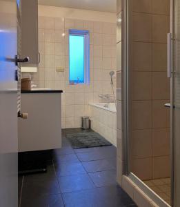 ein Bad mit einem Waschbecken, einer Badewanne und einem Fenster in der Unterkunft Great apartment in Akureyri in Akureyri