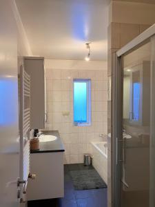 a bathroom with a sink and a tub and a window at Great apartment in Akureyri in Akureyri