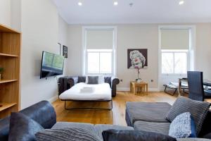 a living room with a couch and a tv at Stunning 1bed Kensington in London