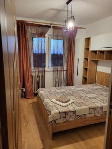 Un dormitorio con una cama y dos ventanas. en Sofia home, en Bucarest