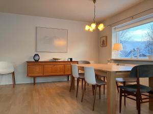 ein Esszimmer mit einem Tisch, Stühlen und einem Fenster in der Unterkunft Great apartment in Akureyri in Akureyri
