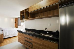 uma cozinha com um lavatório e uma cama num quarto em Ilhéus Praia Hotel em Ilhéus
