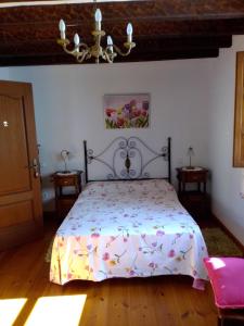 - une chambre avec un lit et une couette à fleurs dans l'établissement Casa Mari Paz Trasvía, à Comillas