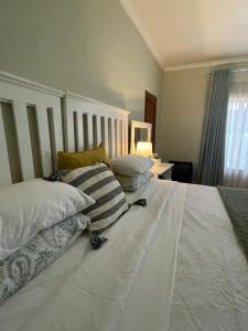 a large white bed with pillows on top of it at Cosy Garden in Maseru