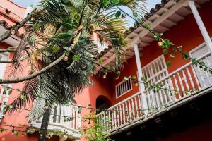 una casa roja con una palmera delante de ella en Magnificent Colonial Mansion en Cartagena de Indias
