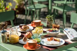 uma mesa coberta com pratos de pequeno-almoço e café em Azalea Park Hotel em Cavalese