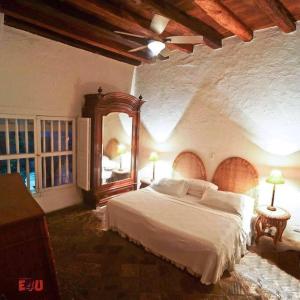 1 dormitorio con 1 cama grande y espejo en Magnificent Colonial Mansion en Cartagena de Indias