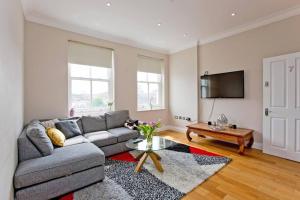 a living room with a couch and a table at Large 2bed Kensington in London