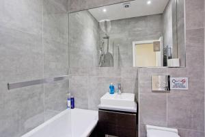 a bathroom with a sink and a toilet and a tub at Large 2bed Kensington in London