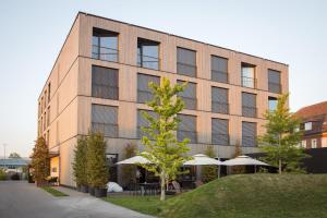 a large brick building with umbrellas in front of it at 2ND HOME HOTEL in Nördlingen