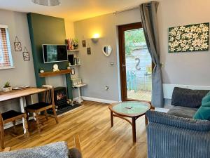 a living room with a couch and a table at Wellinghill Lodge in Cheltenham