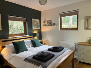 a bedroom with a bed with two towels on it at Wellinghill Lodge in Cheltenham