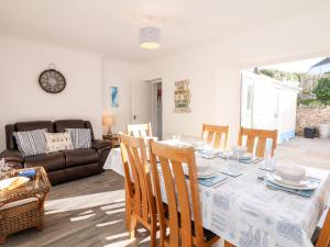 ein Esszimmer mit einem Tisch, Stühlen und einem Sofa in der Unterkunft Quayside View in Brixham