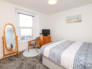 a bedroom with a bed and a dresser and a mirror at Quayside View in Brixham