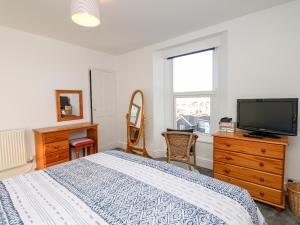 Schlafzimmer mit einem Bett und einem Flachbild-TV in der Unterkunft Quayside View in Brixham