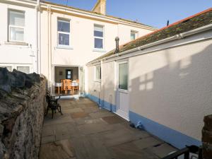 une terrasse en face d'un bâtiment blanc dans l'établissement Quayside View, à Brixham