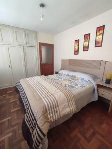 Elegante Apartamento en La Paz في لاباز: غرفة نوم بسرير وخزانة وطاولة