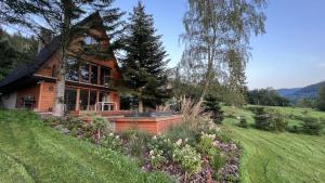 uma casa numa colina com um jardim em Mountain Cottage Gorcówka em Poręba Wielka