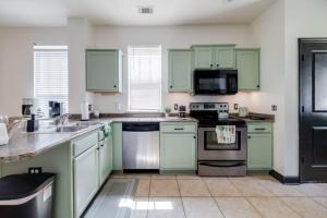 cocina grande con armarios y electrodomésticos verdes en Tupelo Honey - 6 BR, Sleeps 16+, en Savannah