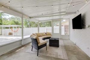 a screened in porch with a couch and a television at The Peach Family Friendly Oasis in Savannah