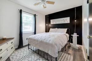 1 dormitorio con 1 cama grande y pared negra en The Peach Family Friendly Oasis en Savannah