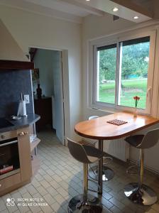 cocina con mesa, sillas y ventana en Gîte A-B Roger en Ganties