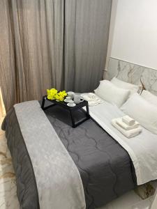 Una cama con una mesa con flores amarillas. en Mergellina Relais 70- Casa vacanze Napoli, en Nápoles
