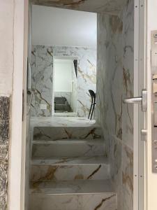 baño con paredes de mármol y espejo en Mergellina Relais 70- Casa vacanze Napoli, en Nápoles