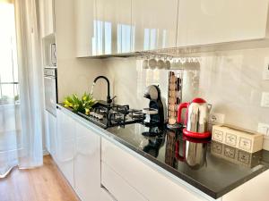 a kitchen with white cabinets and a black counter top at Corso Venezia in Mestre
