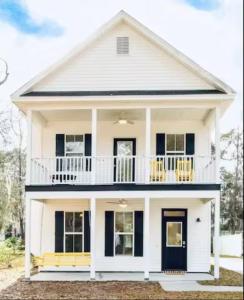 a white house with black windows and a balcony at Honey, I’m Home near Savannah - Seen on HGTV in Savannah
