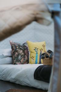 uma cama com almofadas coloridas e um cesto em The Cacoon by Once Upon a Dome @ Misty Mountain Reserve em Stormsriviermond