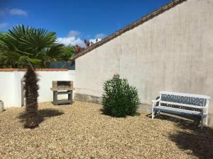 a bench sitting in a yard next to a wall at Maison confortable près de la plage de Châtelaillon in Châtelaillon-Plage +4 photos