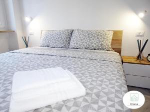 una camera da letto con un letto con un piumone grigio e bianco di Eliana Deluxe & Modern Apartment a Torino