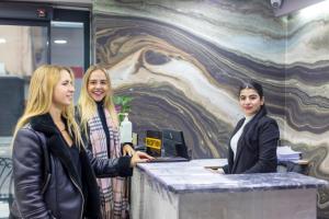 a group of three women standing at a counter at Dem Premium Hotel - Round Trip Airport Service - Istanbul International Airport in Arnavutköy