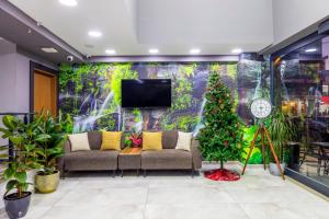 a living room with a couch and a christmas tree at Dem Premium Hotel - Round Trip Airport Service - Istanbul International Airport in Arnavutköy